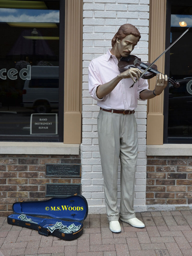 Sidewalk Concert with a statue of a man holding a violin in Carmel, Indiana