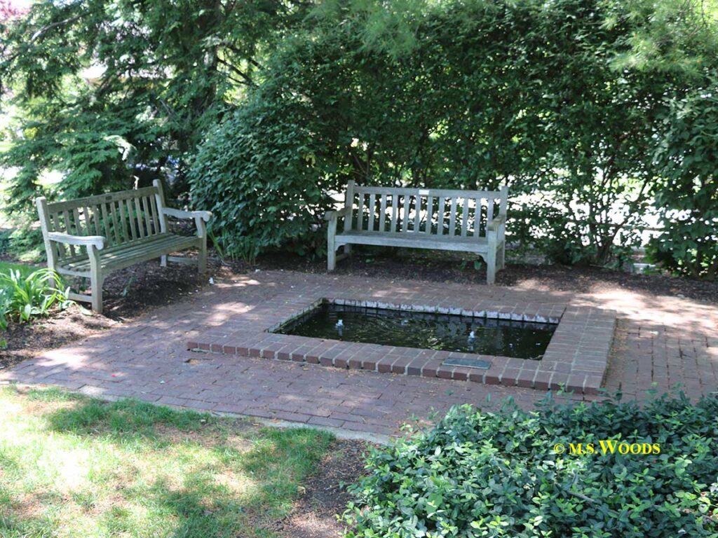 Wooden benches by brick pond in Lincoln Park Zionsville, Indiana
