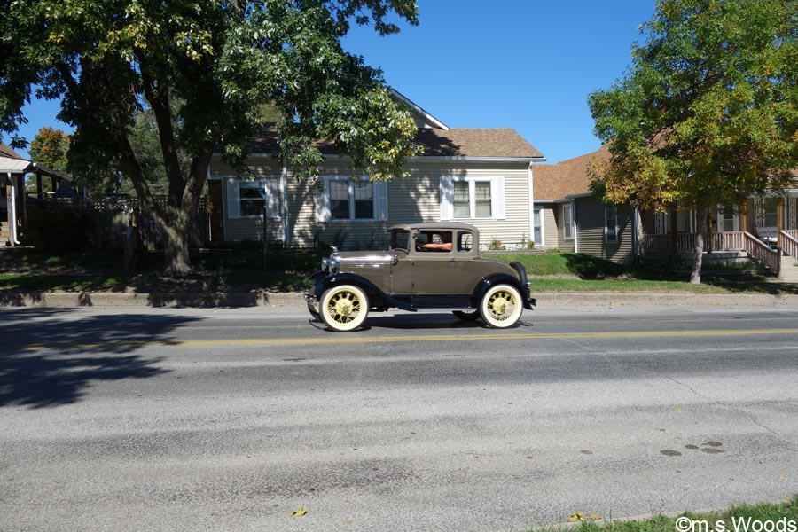 An antique car driving down a street in Mooresville, Indiana