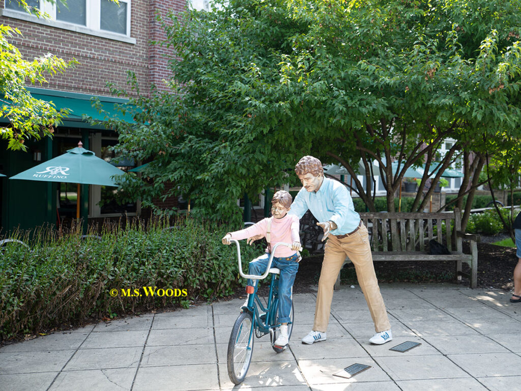 Statue of a man helping a child learn to ride a bike in Carmel, Indiana
